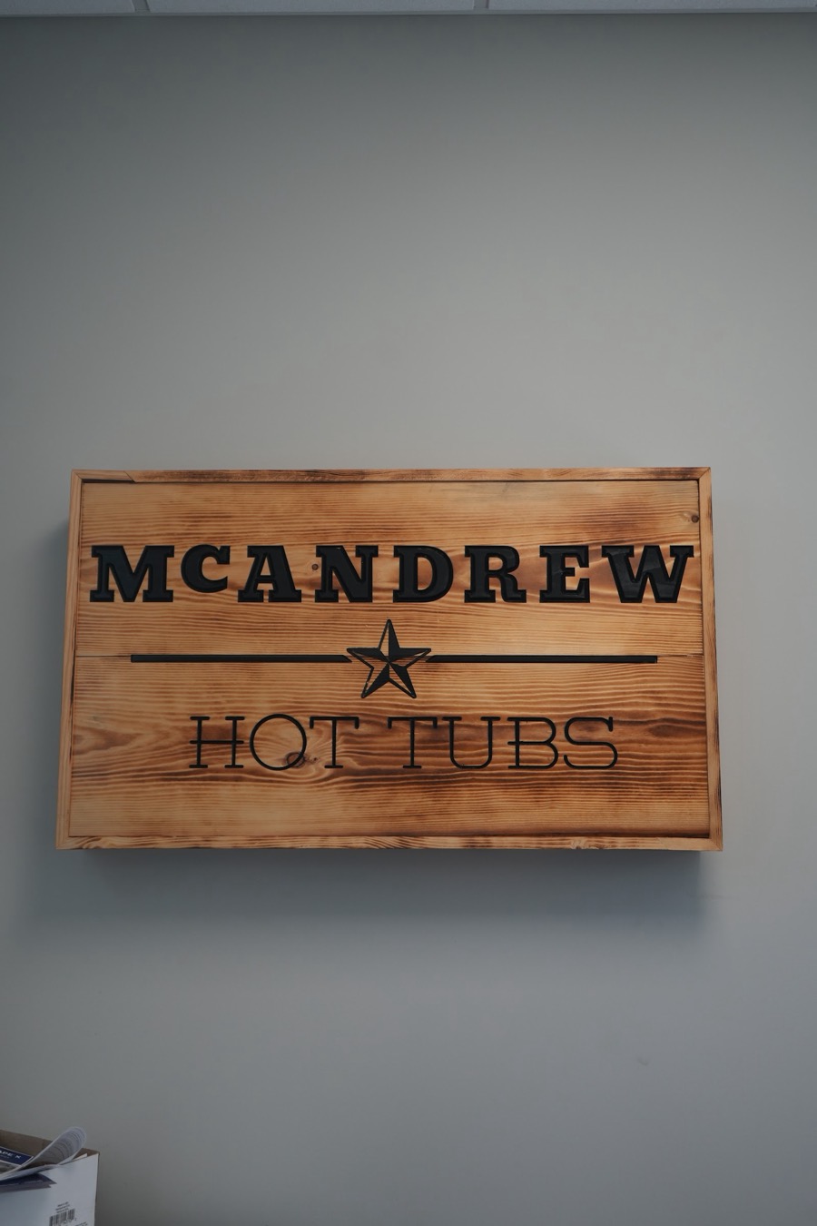 Wooden McAndrew Hot Tubs sign in the Arlington showroom